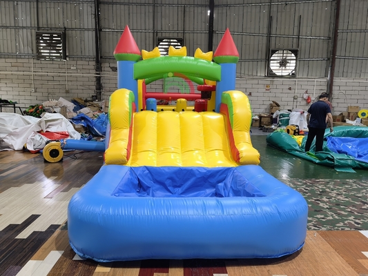 Gioco per feste all'aperto nel cortile sul prato, gonfiabile, bagnato e asciutto, combinazione di castello gonfiabile con percorso a ostacoli, scivolo, piscina e vasca per palline